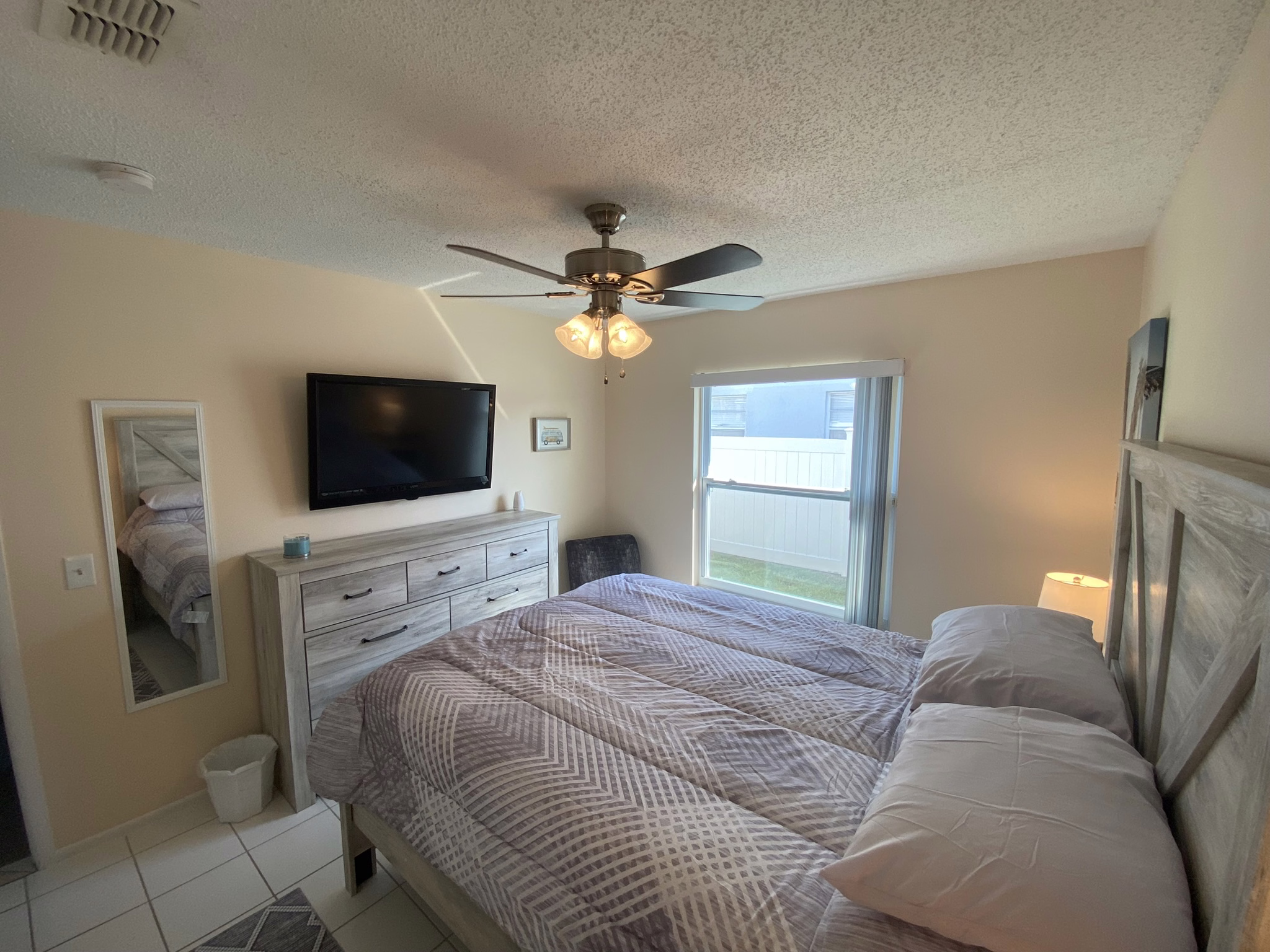 Queen bedroom with mirror and window